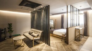 A modern hotel room with a sofa, a bed, a small table, and a potted plant. - Hotel Crape Gyeongsan (Gyeongsan)