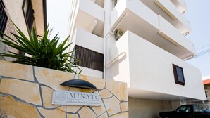 Un muro de piedra con un cartel que dice 'MINATO Chatan Seaside Condominium'.