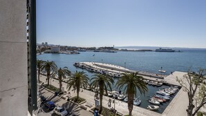 A marina with boats docked, a clear sky, and a distant cityscape. - Seaview Luxury Retreat (Split)