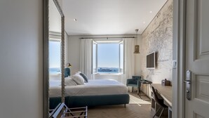 A modern hotel room with a large bed, a desk, and a view of the sea. - Seaview Luxury Retreat (Split)