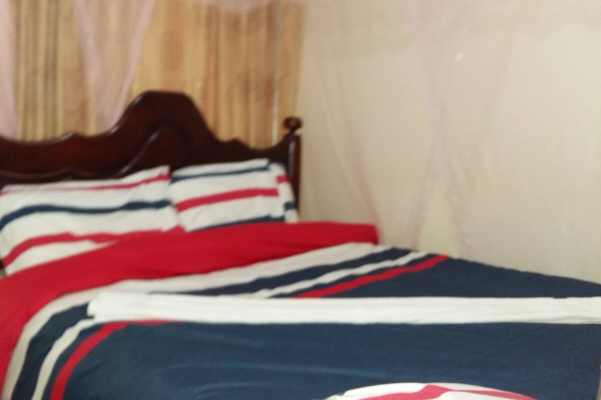 A bed with striped bedding and a wooden headboard.