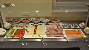 A buffet with various food items including salads, meats, and seafood. - Avalon Ferienwohnungen Bellevue (Fehmarn)