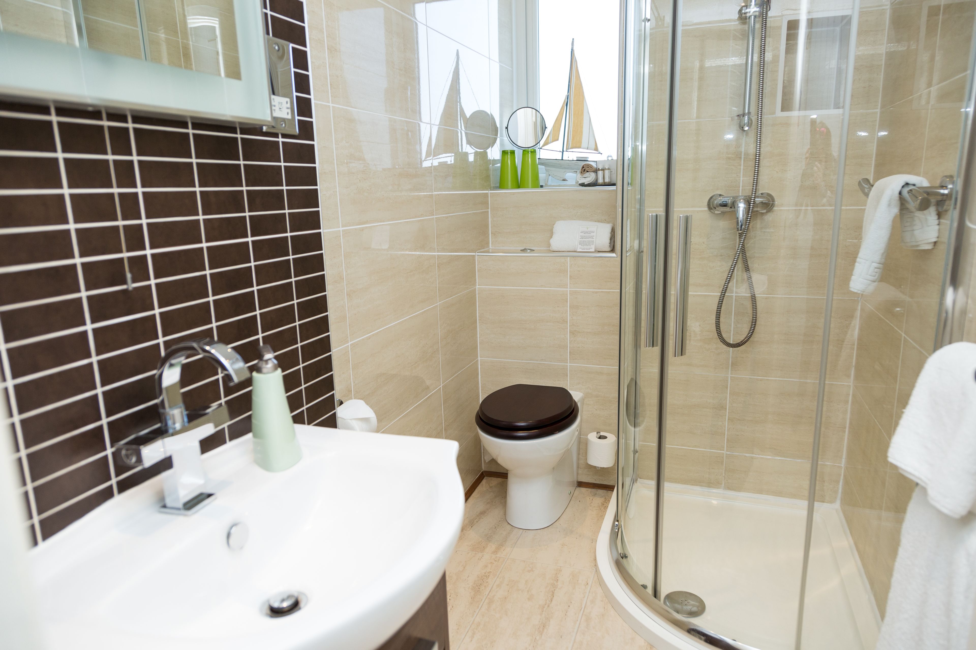Une salle de bain moderne avec un lavabo, des toilettes et une douche à parois de verre.