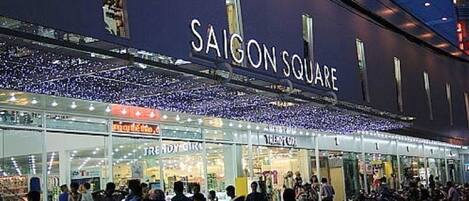 Ein belebtes Einkaufsgebiet mit der Aufschrift "SAIGON SQUARE" über dem Eingang.