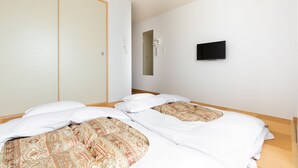 A hotel room with two beds, a television, and a sliding door. - Kansai Seaside Hotel (Kaizuka)