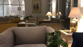 Un salon moderne avec un canapé, une table basse en verre et un vase contenant une plante.