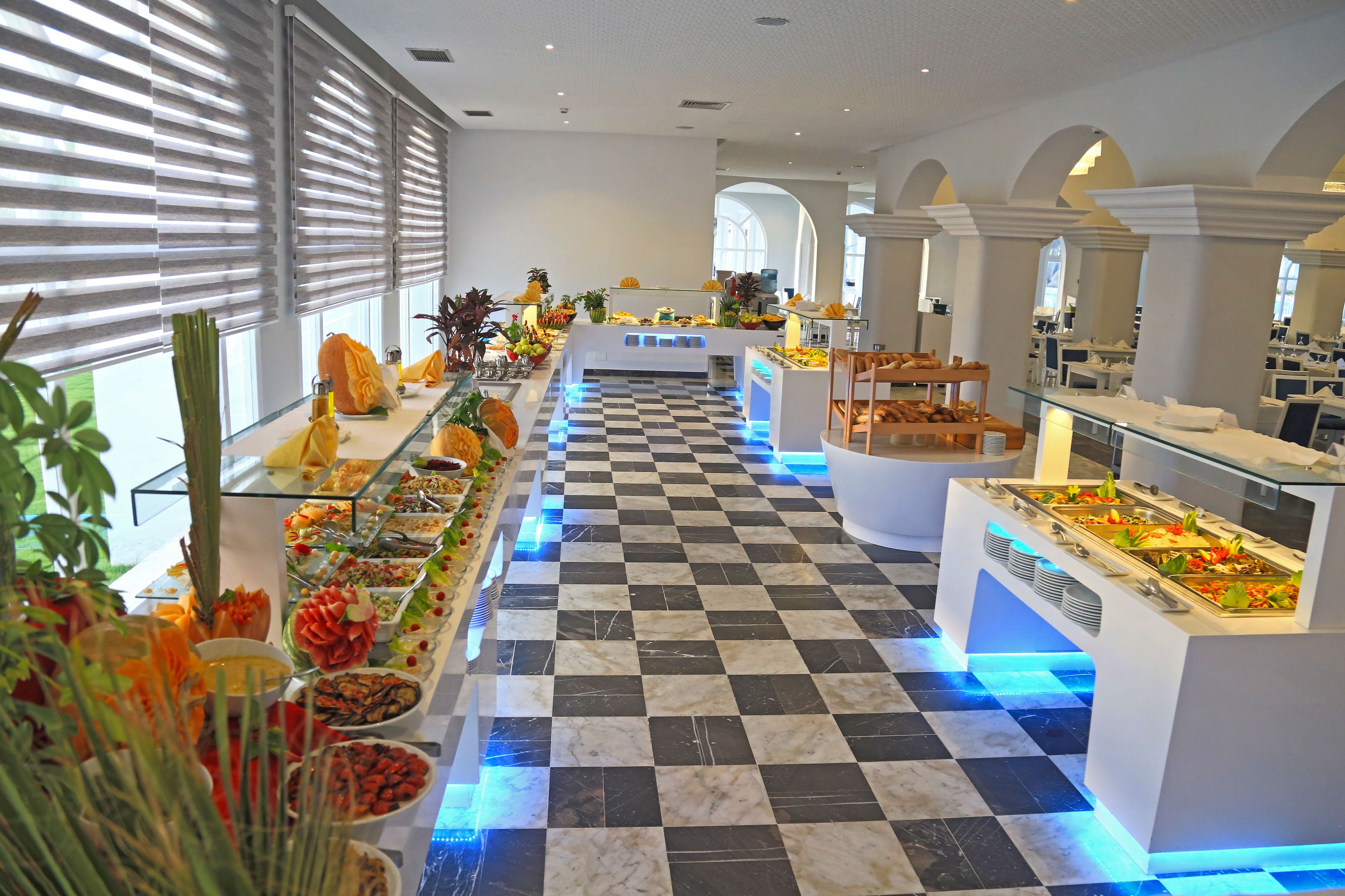 A buffet with various food options, a checkered floor, and a modern interior design.