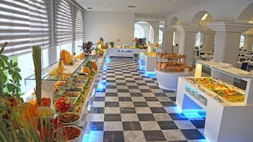 A buffet with various food options, a checkered floor, and a modern interior design.