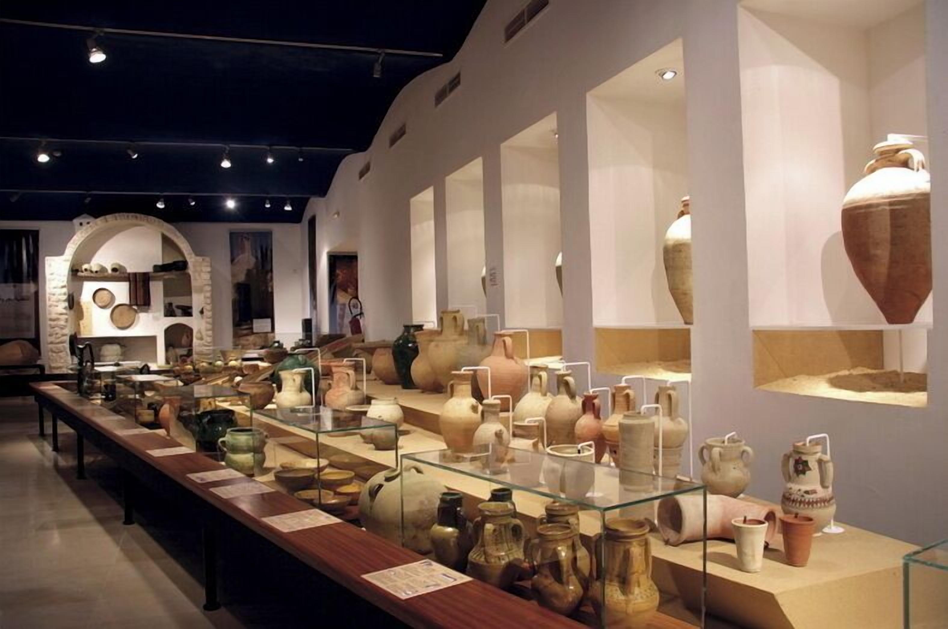 Una mostra museale con diverse antiche ceramiche esposte in teche di vetro.