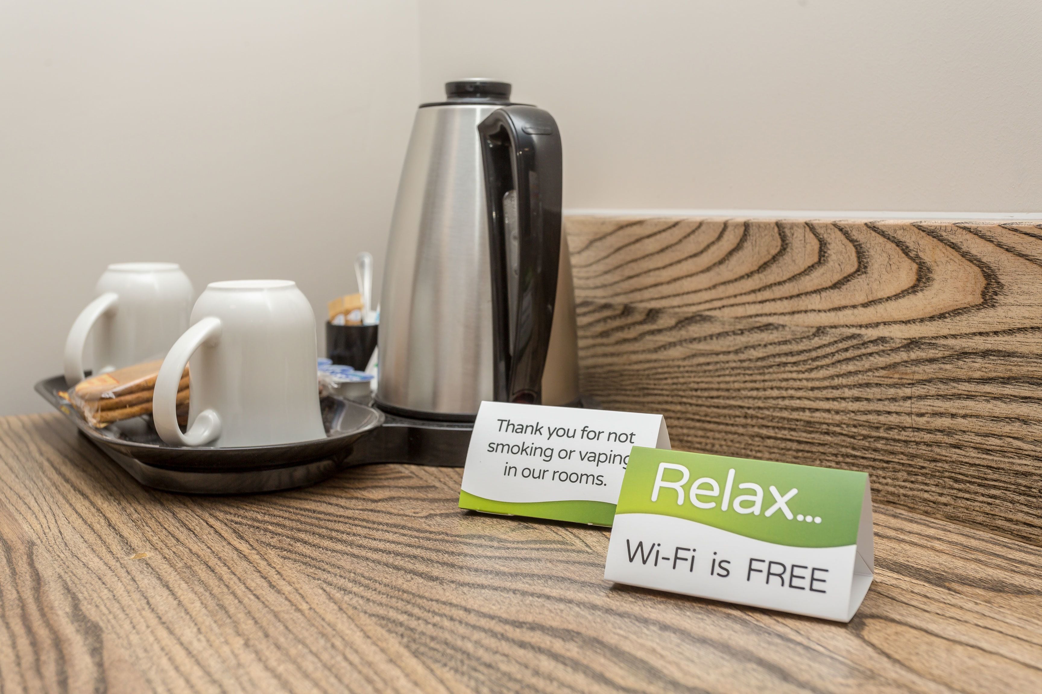 A tray with a coffee pot, mugs, and a sign stating "Wi-Fi is free".