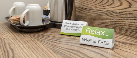 A tray with a coffee pot, mugs, and a sign stating "Wi-Fi is free".