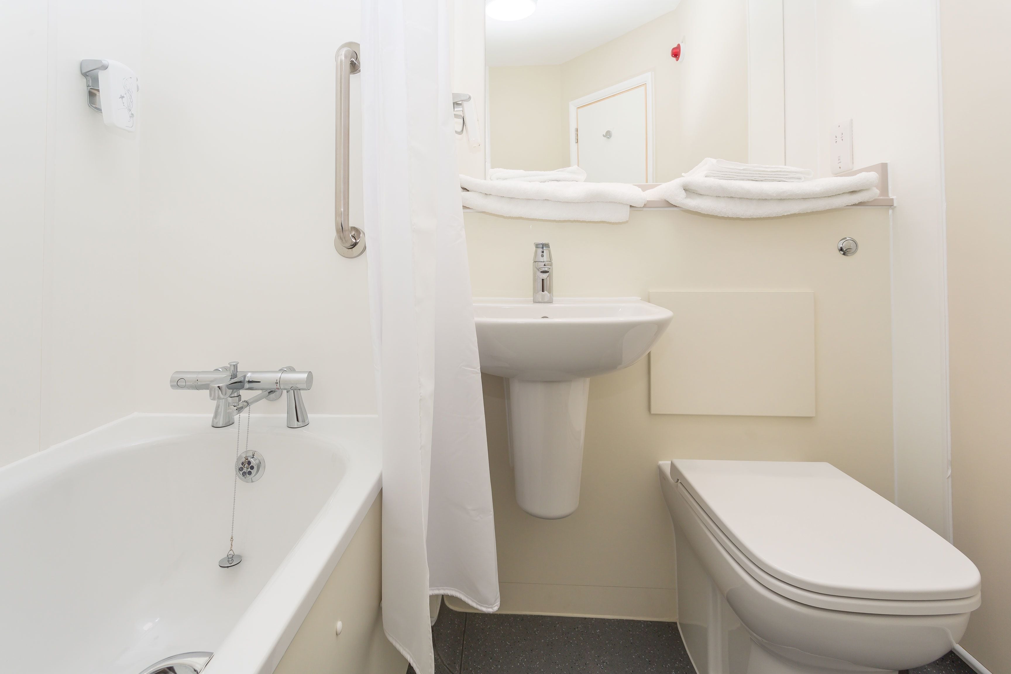 Un baño con bañera, lavamanos e inodoro.