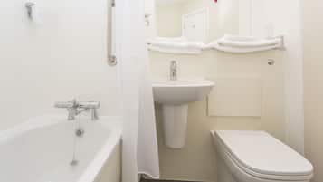 Un baño con bañera, lavamanos e inodoro.
