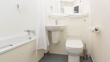 A small, clean bathroom with a bathtub, sink, and toilet.