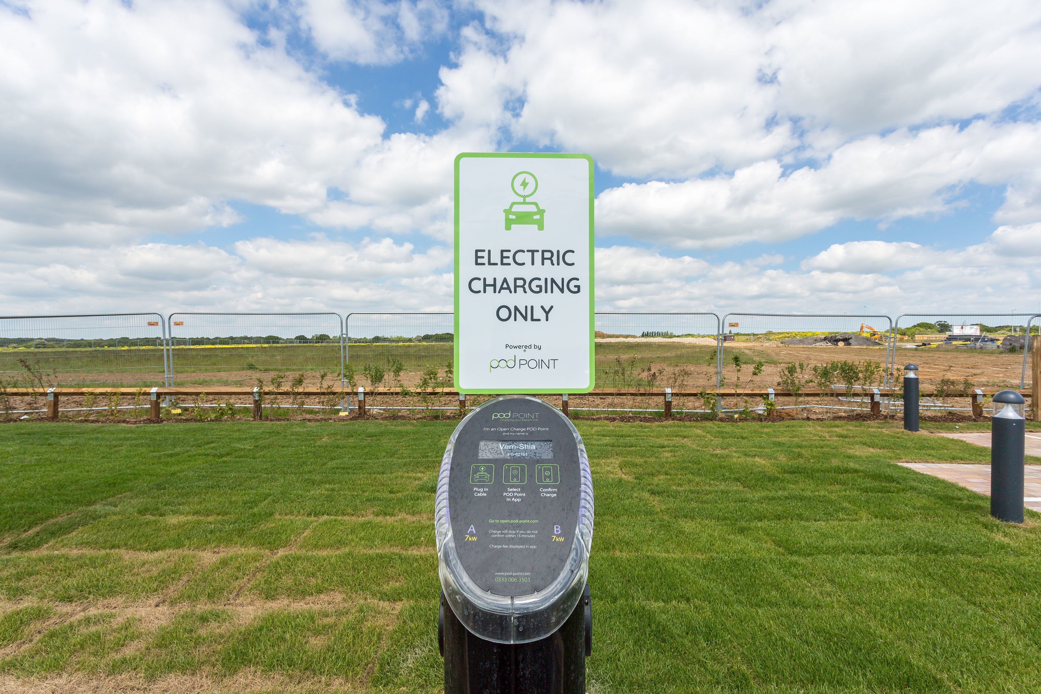 An electric charging station with a sign indicating it is for electric vehicles only, powered by Pod Point.