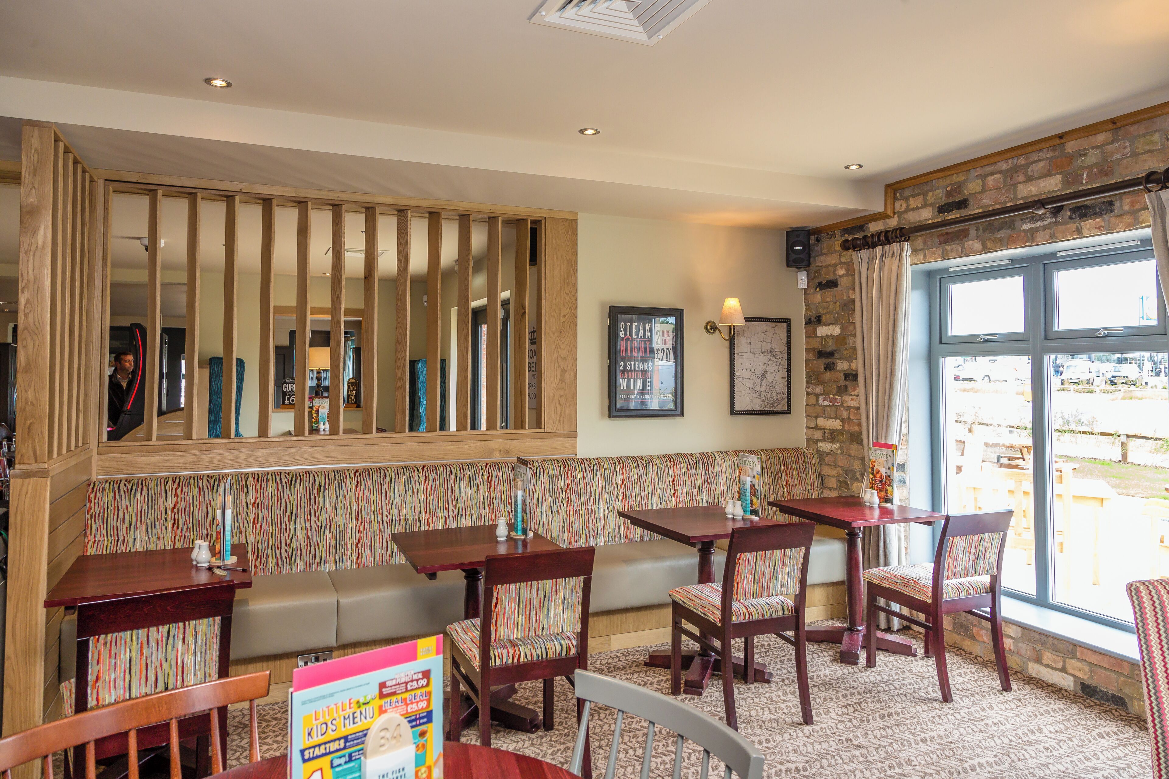 Un ristorante con arredi in legno, una parete a righe e un'ampia finestra con vista.