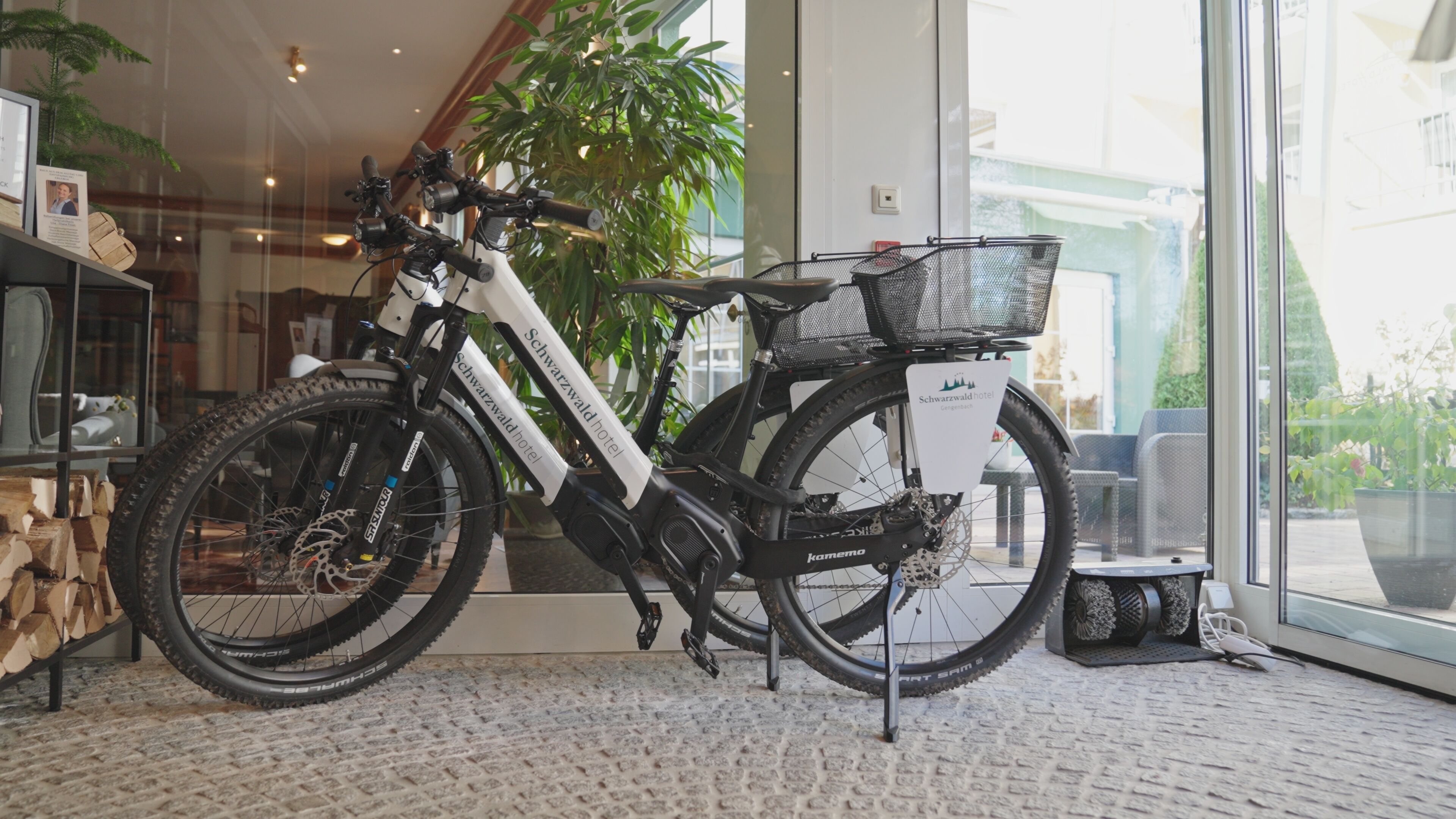 A bicycle with a basket and a sign indicating it is parked at a hotel.
