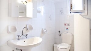 A bathroom with a white sink, a toilet, and a mirror. - Apartment Alex for 4 (Mykonos)
