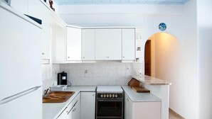 A compact kitchen with white cabinets, a built-in oven, and a coffee machine. - Apartment Alex for 4 (Mykonos)