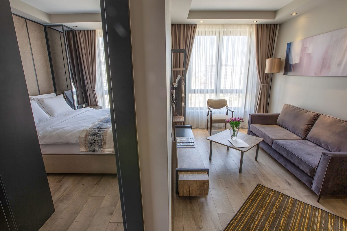 Junior suite, 1 slaapkamer, uitzicht op stad, op de hoek | 1 slaapkamer, een minibar, een kluis op de kamer, een bureau