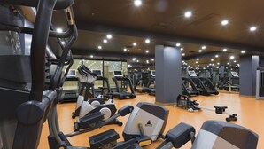 A gym with various exercise equipment, including treadmills and weight machines, arranged in a spacious layout. - Shimall Hotel (Gaziantep)