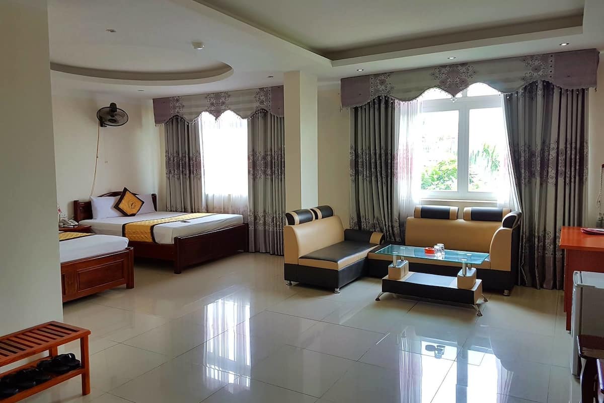 A hotel room with a bed, sofa, and a small table.
