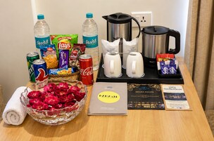 A table with various items including snacks, beverages, a coffee maker, and a brochure.