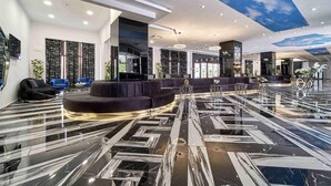A modern lobby with a curved seating area, a marble floor, and a ceiling with a sky-like design. - Prestige Hotel and Aquapark (Golden Sands)