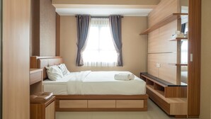 A bedroom with a bed, bedside tables, a wardrobe, and a window with curtains. - 3BR with Sofa bed at Gateway Pasteur Apartment (Cimahi)