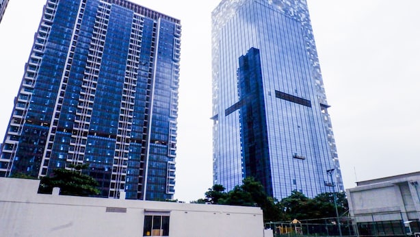 Two high-rise buildings with reflective glass facades, one with a grid-like pattern and the other with a more uniform appearance. - Furnished 1BR City View Casa Grande Apartment (Jakarta)