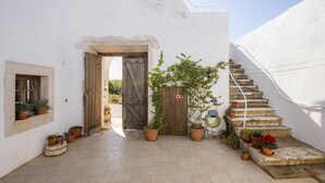 A courtyard with a wooden door, potted plants, and a stone staircase. - F - Casa do Garibaldi in Quinta das Alagoas by DreamAlgarve (Lagos)