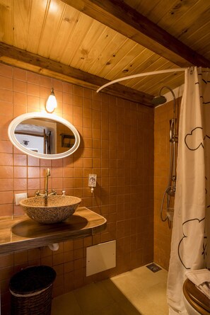 A bathroom with a wooden ceiling, a round mirror, a granite sink, and a shower curtain. - F - Casa do Garibaldi in Quinta das Alagoas by DreamAlgarve (Lagos)