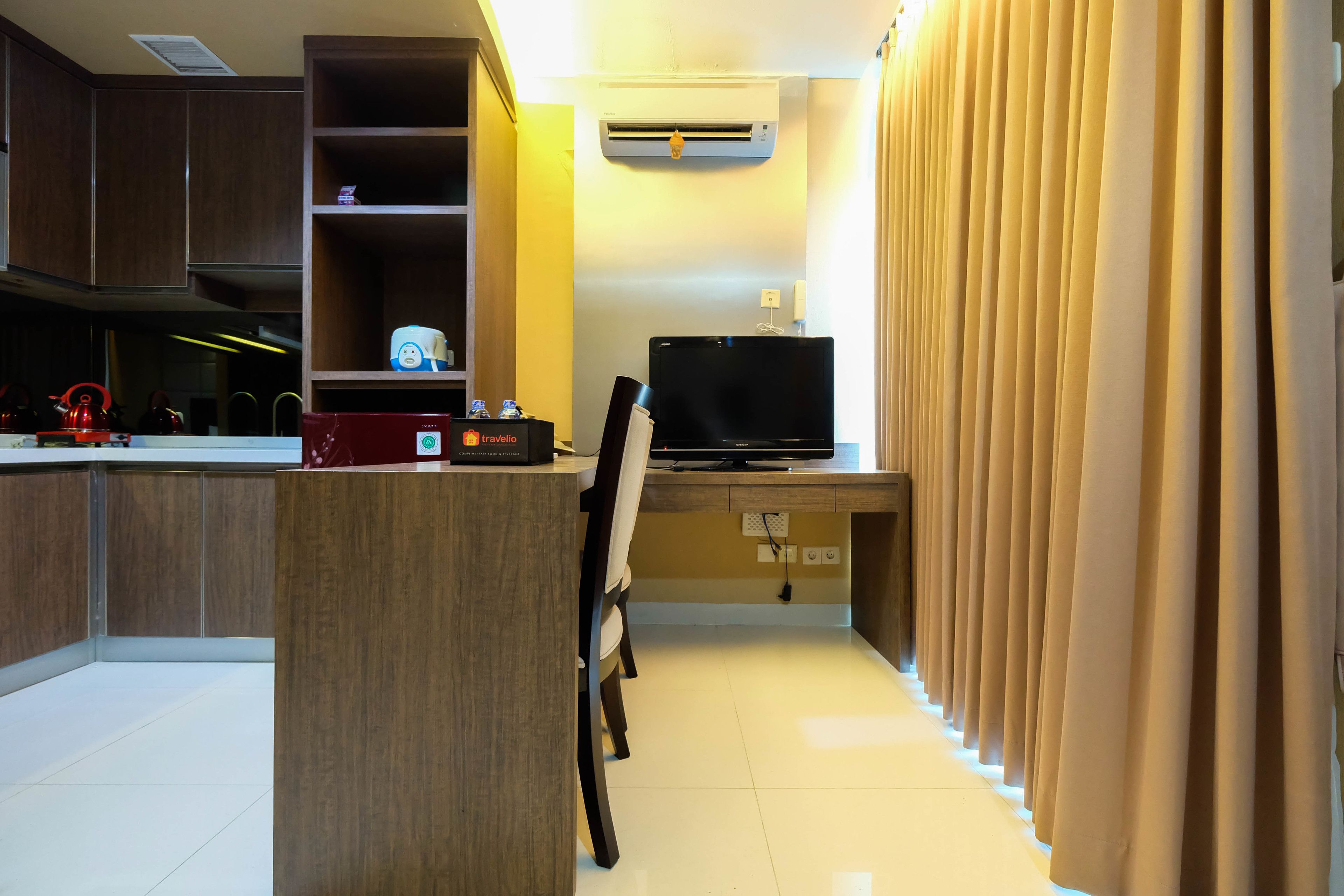 A compact kitchen with a built-in stove, a microwave, and a small refrigerator.