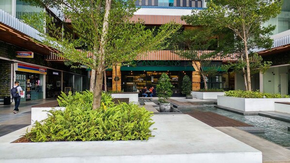 A modern outdoor area with seating, a café, and a water feature.