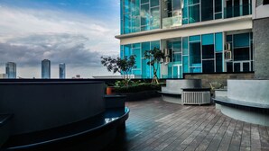 A modern building with large windows and a rooftop garden. - Spacious and Artsy Studio Apartment at Brooklyn Alam Sutera (South Tangerang)