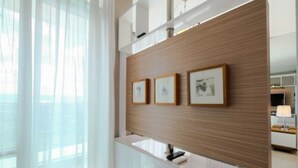 A modern interior with a wooden panel wall, a white console, and framed artwork.