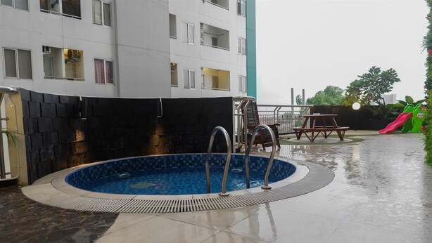A swimming pool with a tiled edge, a metal ladder, and a picnic table.