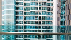 A modern high-rise building with multiple floors, large windows, and a glass facade. - Well Equipped 1BR Brooklyn Alam Sutera Apartment near IKEA (South Tangerang)