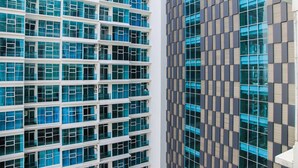 A modern building with multiple floors, large windows, and a grid-like facade. - Simply Studio Room Brooklyn Apartment (South Tangerang)