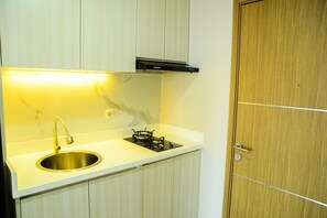 Room | Private kitchen | Fridge, stovetop, cookware/dishes/utensils - Sophisticated Studio at The Oasis Apartment (Cikarang)