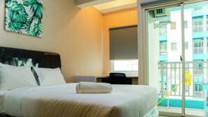 Une chambre d’hôtel avec un lit, un bureau et une vue sur un bâtiment situé à l’extérieur.
