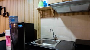 A kitchen with a black countertop, stainless steel sink, and a water dispenser.