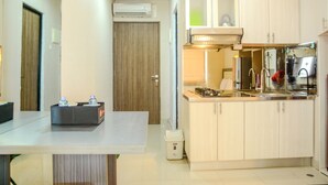A compact kitchen with a sink, stove, and cabinets. - Prime Location Studio Apartment at Elpis Residence near Ancol (Jakarta)