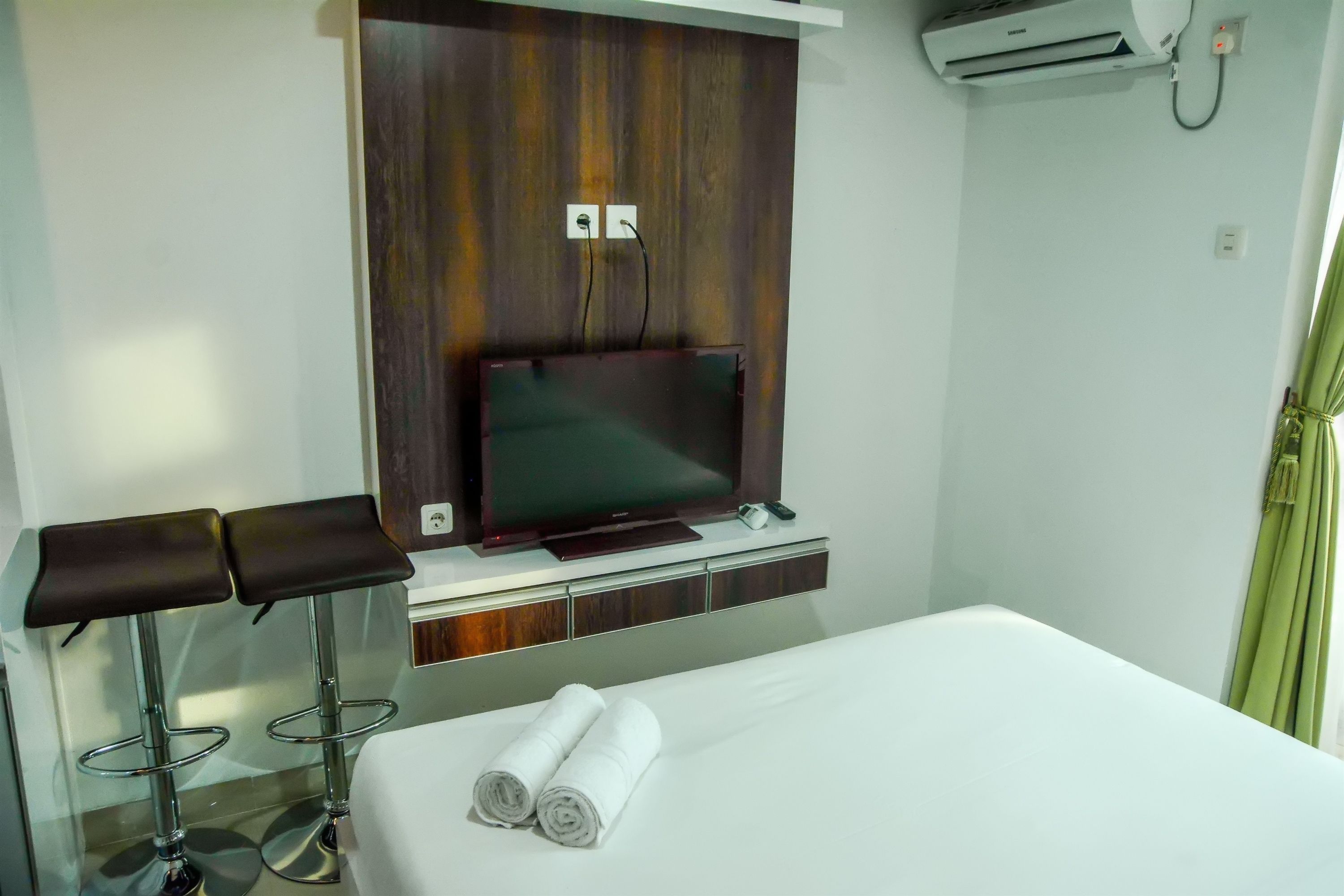 Ein Hotelzimmer mit einem Bett, einem Fernseher und einer Minibar.