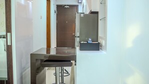 A modern bathroom with a glass-enclosed shower, a stainless steel sink, and a mirror. - Fully Furnished Studio Apartment @ The Enviro (Cikarang)