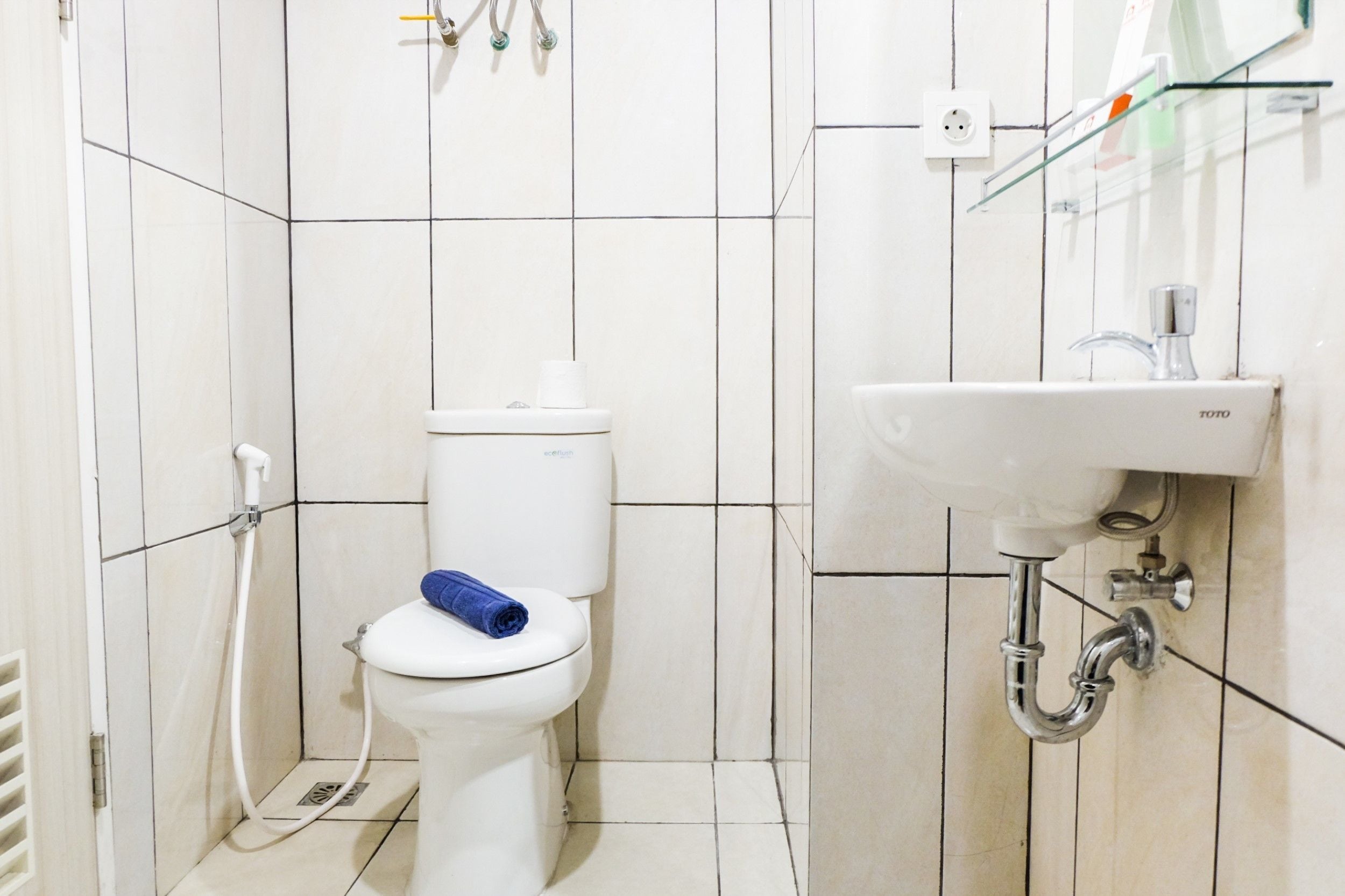 A small, clean bathroom with a toilet, a sink, and a shower.