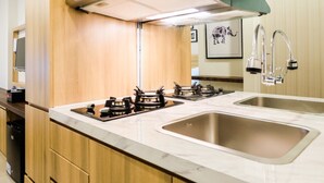 A modern kitchen with wooden cabinets, a double sink, and a gas stove.