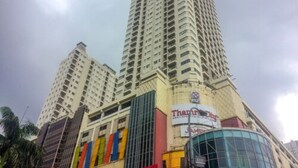 Un grand immeuble à plusieurs étages, sur lequel on peut voir une enseigne bien visible indiquant « Tham Park City ».