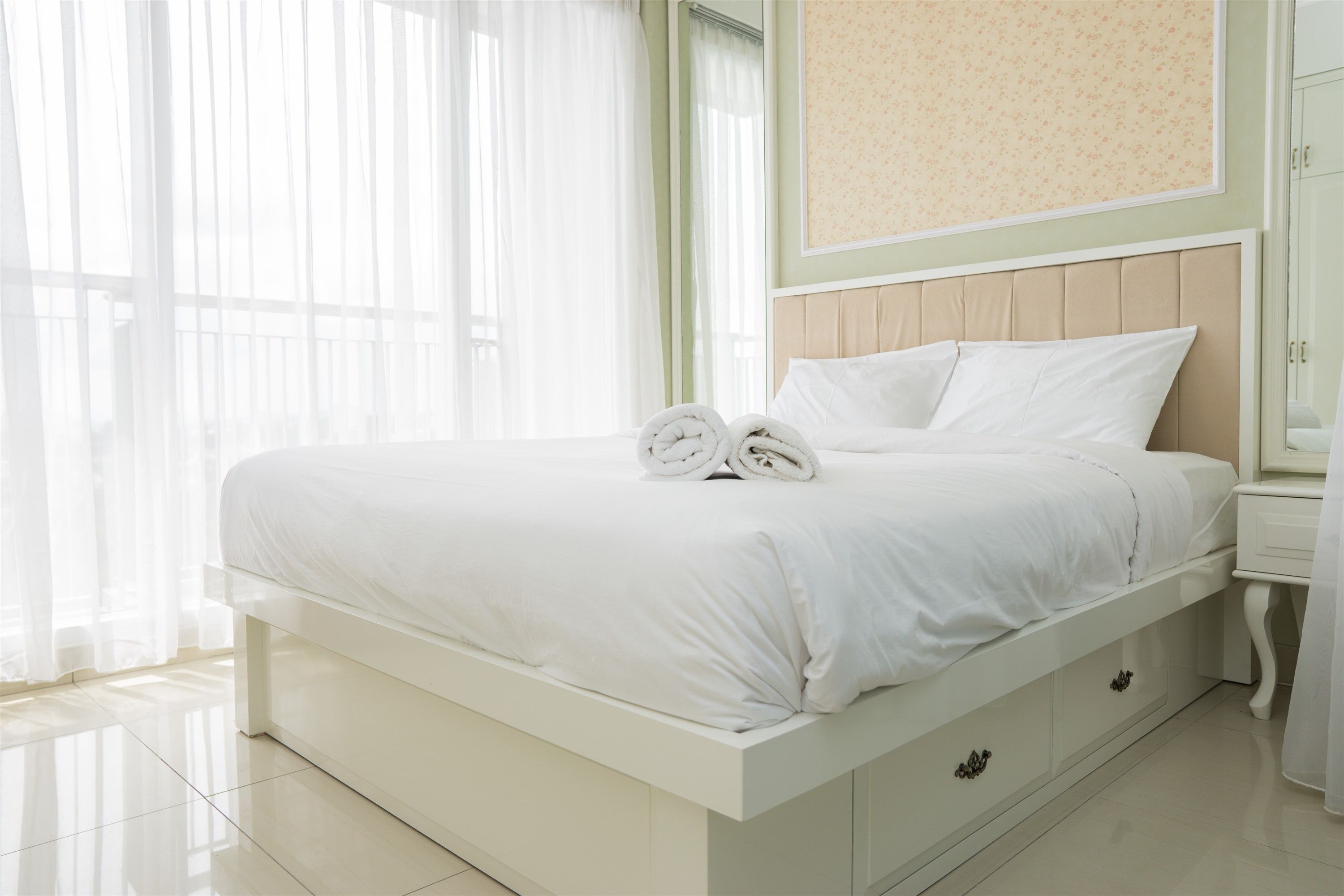 Un dormitorio moderno con una cama grande, una mesita de noche y un espejo.