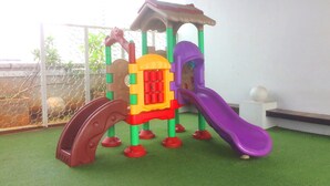 A children's play structure with a slide, climbing area, and a small house-like shelter. - Simply Homey Studio Room at GP Plaza Apartment (Jakarta)